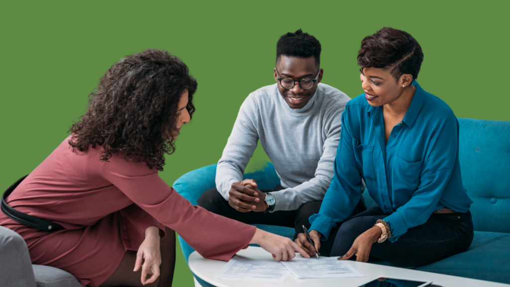A small business consultant guiding an entrepreneurial couple through signing loan documents or a business contract.