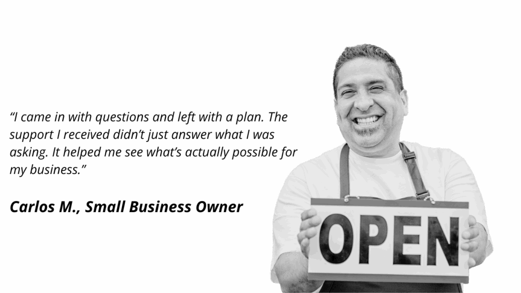 Black and white photo of a smiling man wearing an apron, holding up a sign that says "OPEN" against a solid black background.